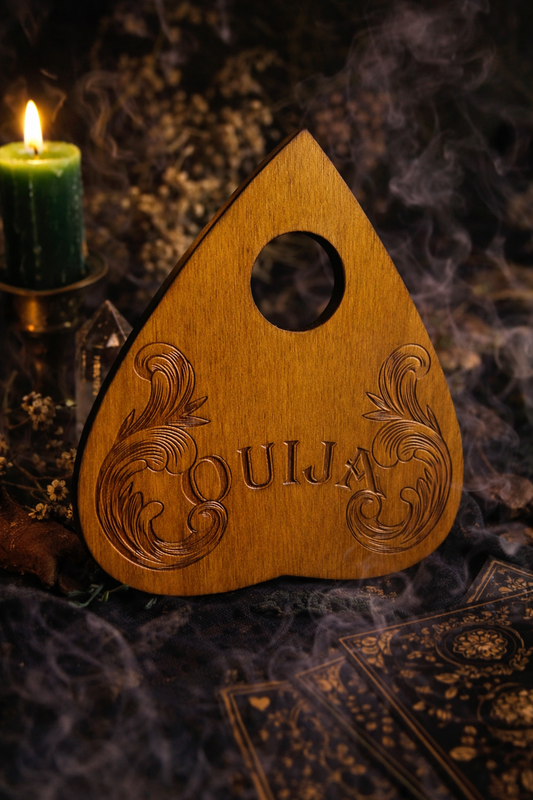 Planchette ouija en bois naturel gravé à la main, utilisée pour la divination, mise en scène dans un univers occult et décoration ésotérique