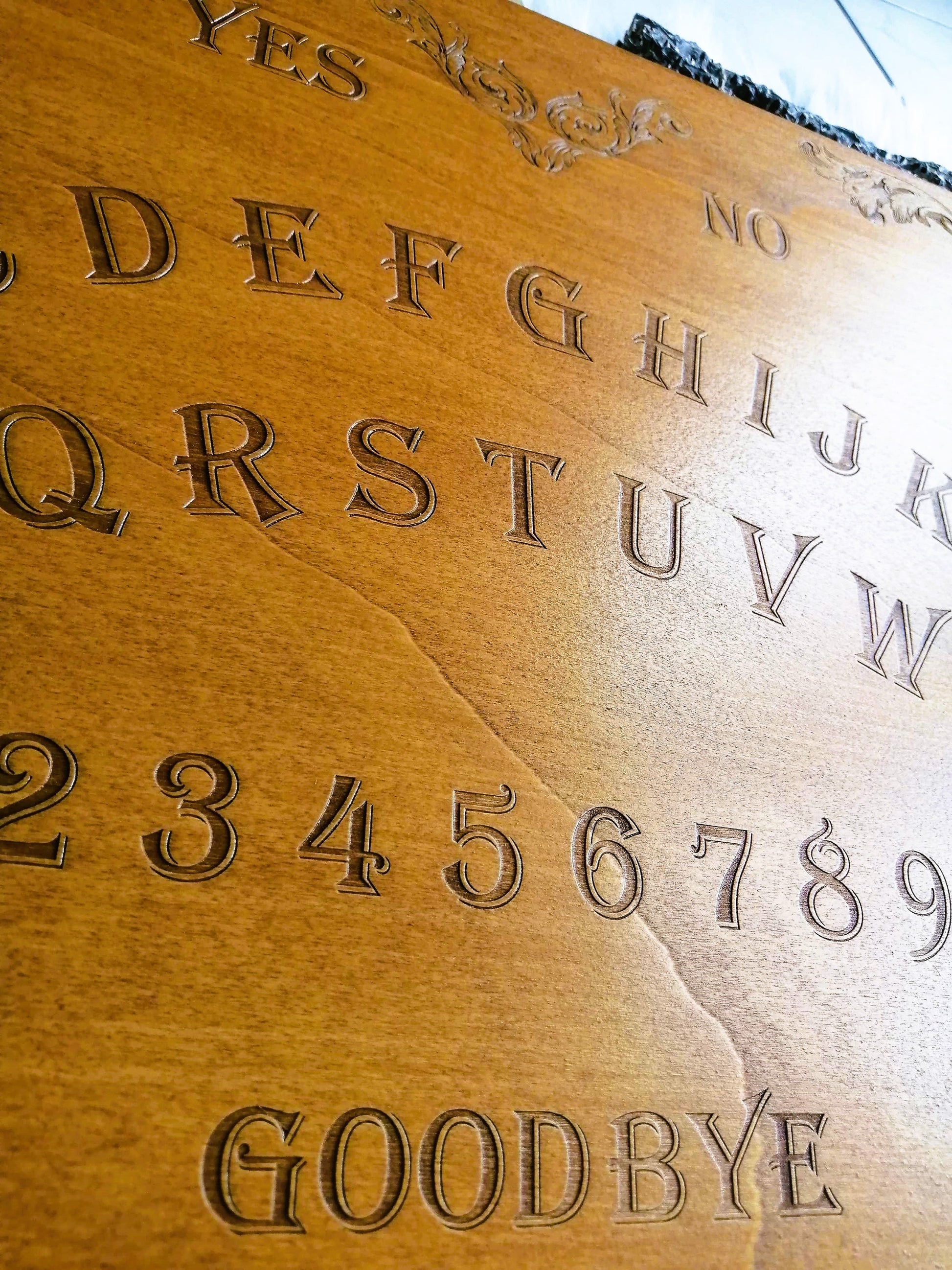 Ambiance de séance de spiritisme avec la planche Ouija La Baroque en bois gravé